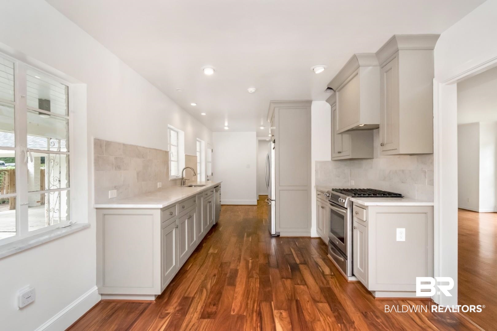 4 Turnout Lane Mobile, AL 36608 - Photo 11 of 53 Kitchen with stainless steel appliances, decorative backsplash, dark wood finished floors, gray cabinetry, and light stone counters