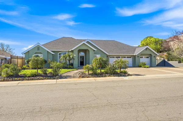 a front view of a house with a yard and potted plants