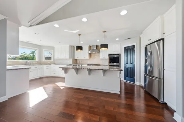 a kitchen with stainless steel appliances granite countertop a sink stove and refrigerator