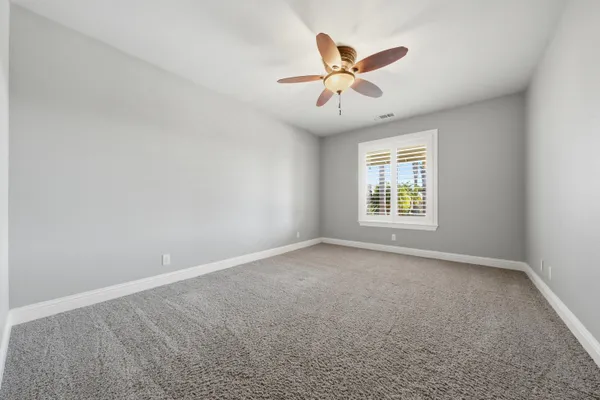 a bathroom with granite countertop white cabinets and a sink