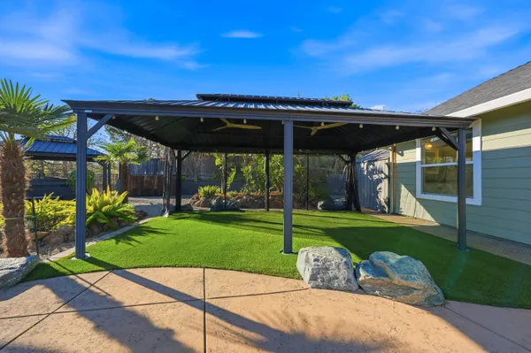 a view of a patio with a table and chairs under an umbrella