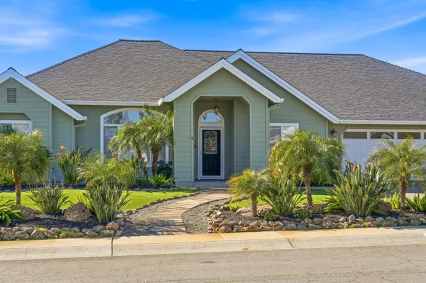 a front view of a house with a yard and potted plants