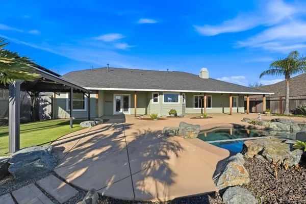 a front view of a house with a yard and potted plants