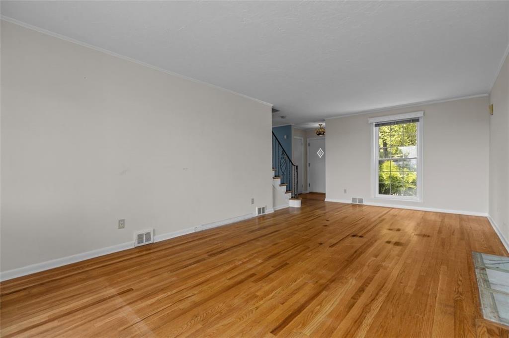 The front of the living room has a floor-to-ceiling window providing delightful daylight.