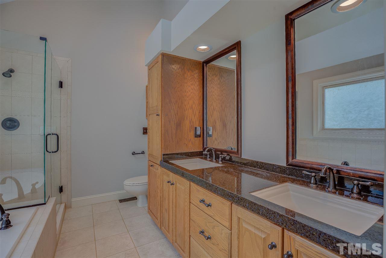 11909 Pembridge Lane Raleigh, NC 27613 - Photo 22 of 30 a spacious bathroom with a granite countertop sink and a mirror