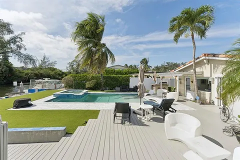 a view of a swimming pool with a lounge chair and potted plants