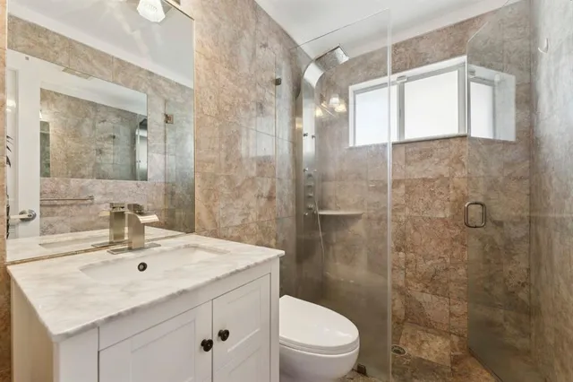 a bathroom with a sink toilet a mirror and shower