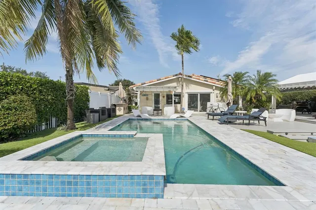 a view of a house with swimming pool and sitting area