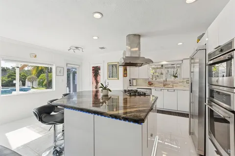 a kitchen with stainless steel appliances granite countertop a sink and a refrigerator