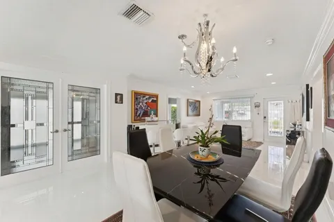 a view of a dining room with furniture a chandelier and wooden floor