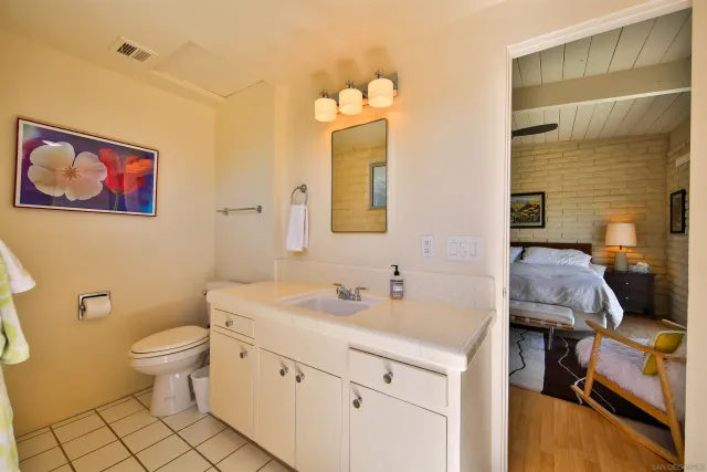 a bathroom with a granite countertop sink a toilet and a mirror