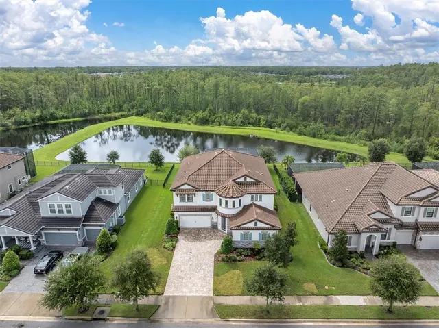 an aerial view of a house with a garden and lake view