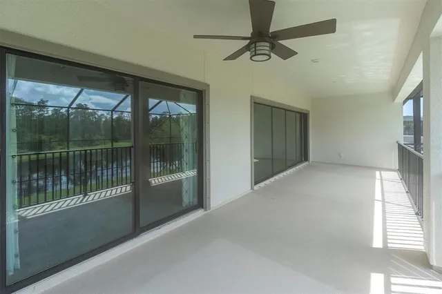 a view of an empty room and chandelier fan