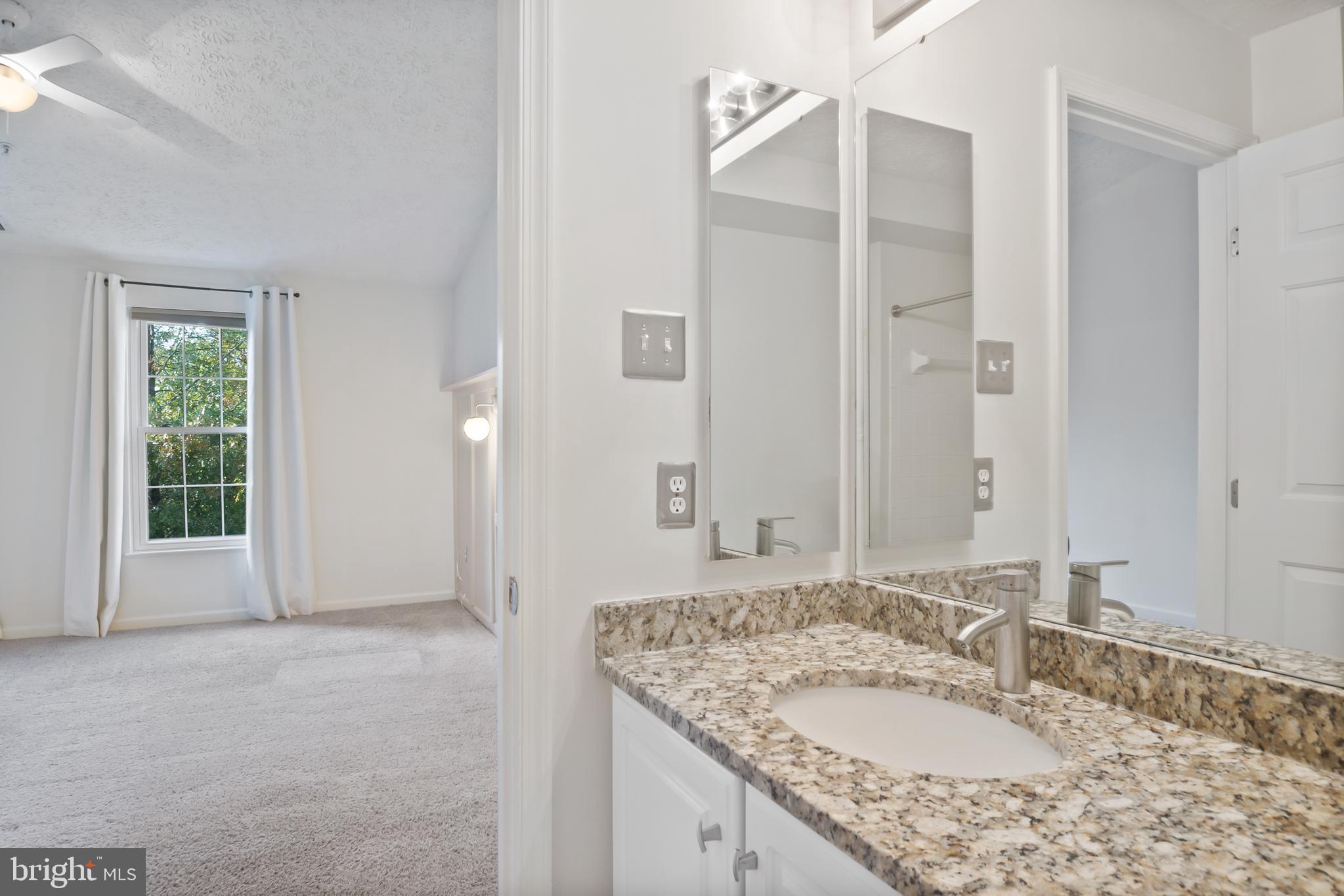 8265 Poplar Mill Road, Unit 8265 Nottingham, MD 21236 - Photo 18 of 35 a bathroom with a granite countertop sink and a mirror