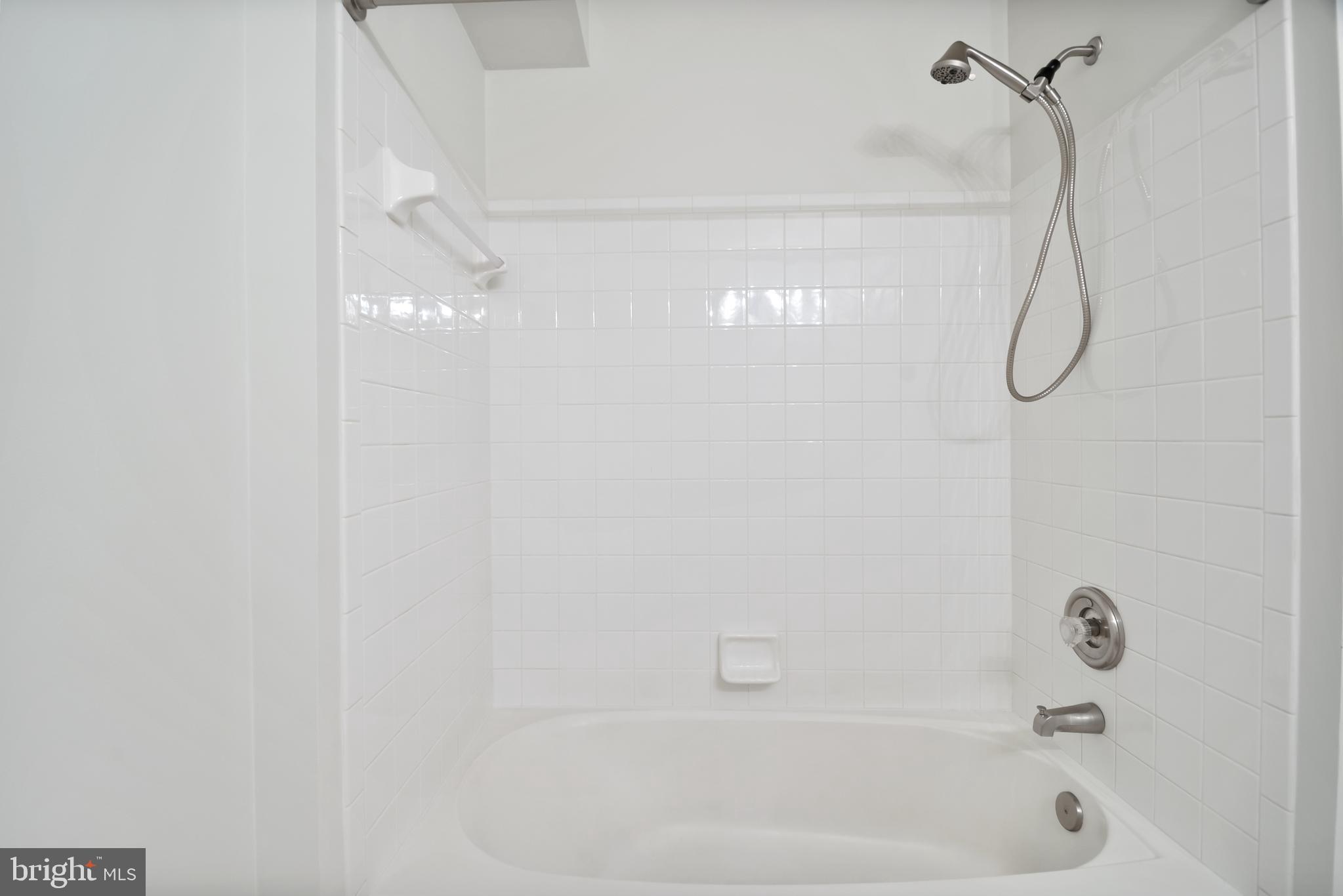 8265 Poplar Mill Road, Unit 8265 Nottingham, MD 21236 - Photo 19 of 35 a bathroom with a bath tub with a shower