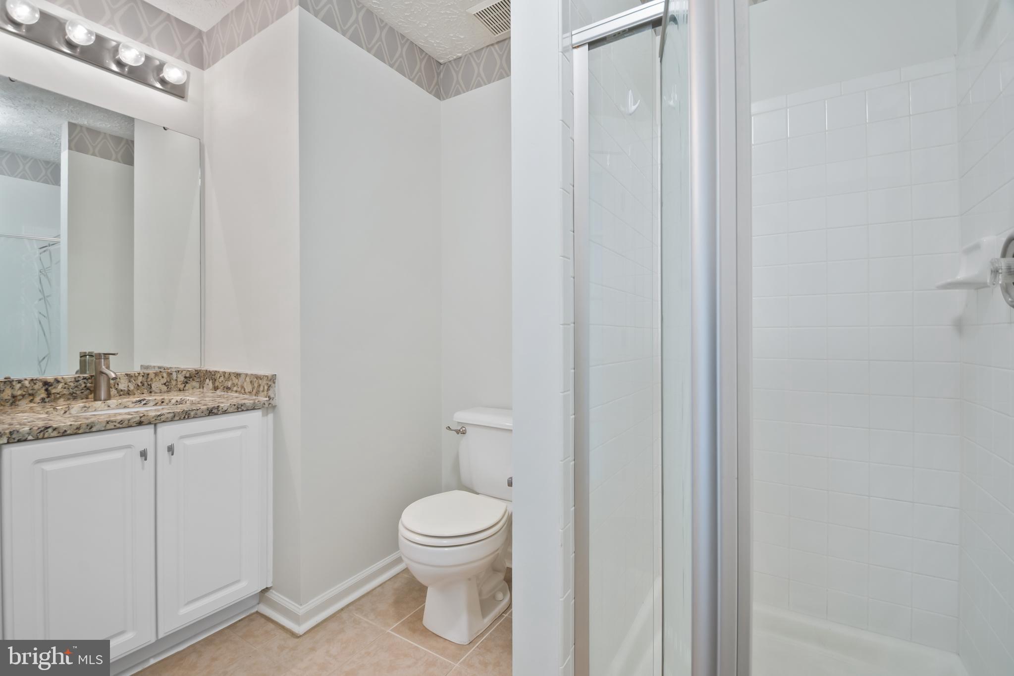 8265 Poplar Mill Road, Unit 8265 Nottingham, MD 21236 - Photo 24 of 35 a bathroom with a granite countertop sink toilet and a mirror