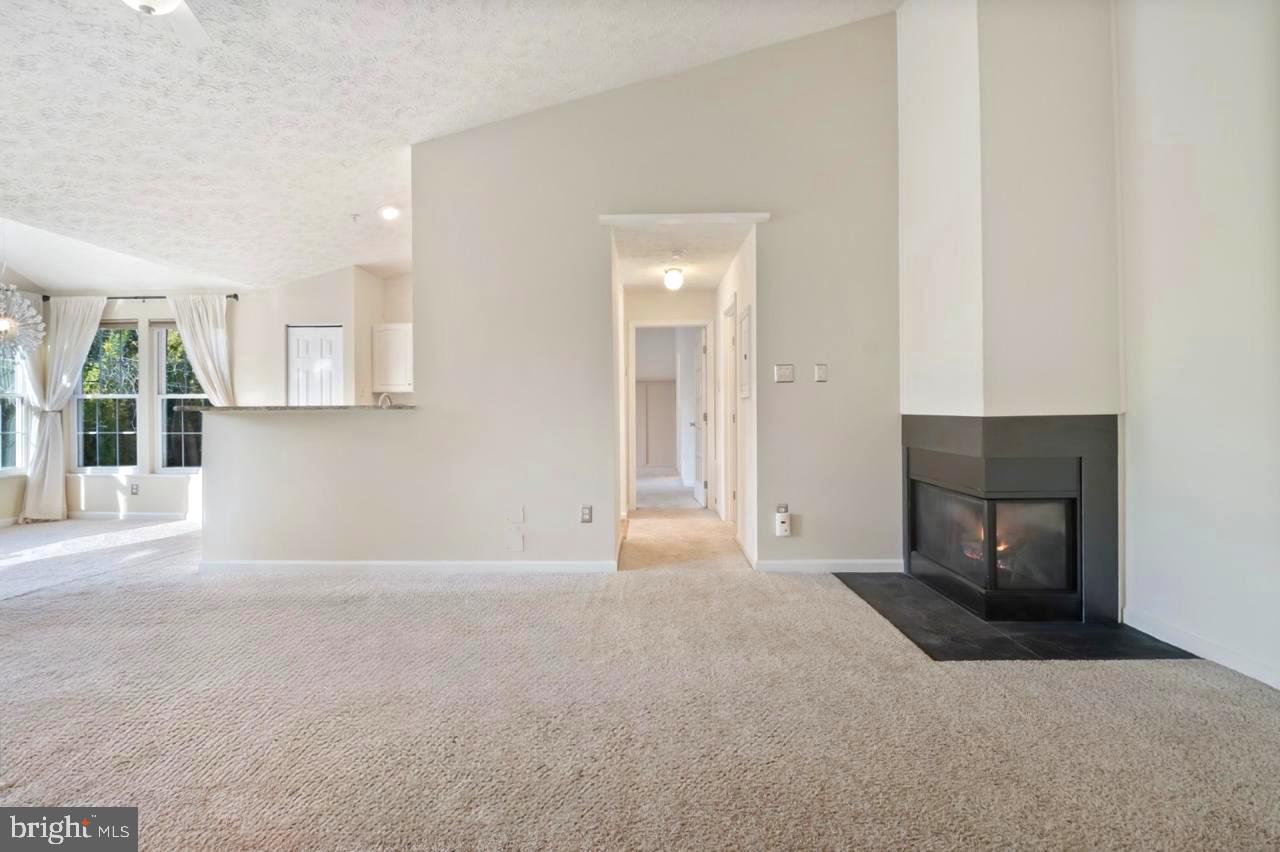 8265 Poplar Mill Road, Unit 8265 Nottingham, MD 21236 - Photo 3 of 35 a view of an empty room with a fireplace and a window