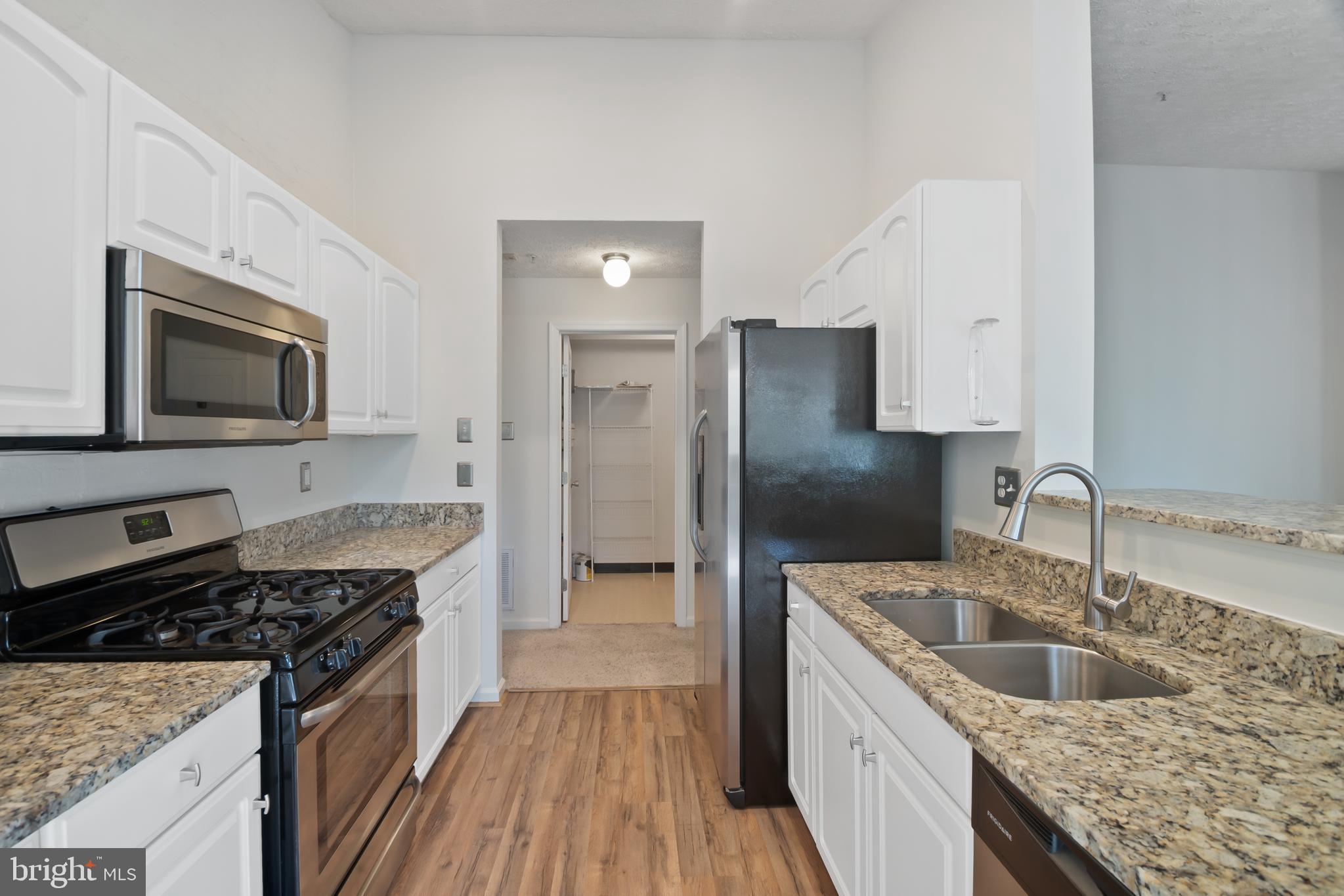 8265 Poplar Mill Road, Unit 8265 Nottingham, MD 21236 - Photo 8 of 35 a kitchen with a stove sink and refrigerator