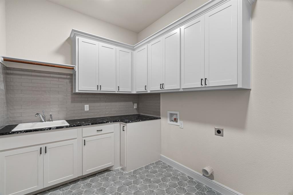 161 Frontera Drive Decatur, TX 76234 - Photo 23 of 39 Laundry Room is Complete with Concrete Tile Floors, Abundant Cabinetry, Sink & Extra Fridge or Freezer Space