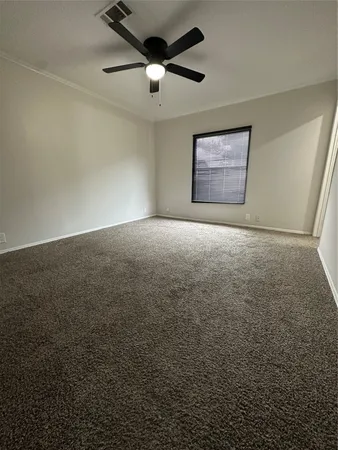 en empty room with windows and ceiling fan
