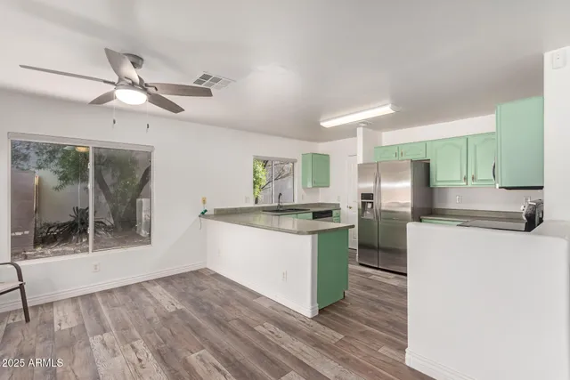 a kitchen with stainless steel appliances kitchen island wooden floors and view living room