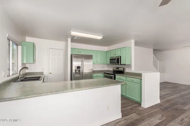 a kitchen with stainless steel appliances granite countertop a sink and a stove top oven