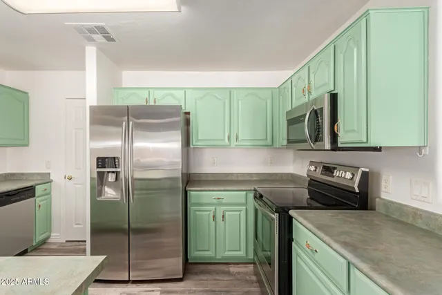 a kitchen with a refrigerator a sink and cabinets