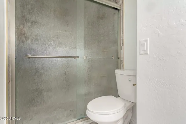 a white toilet sitting next to a shower