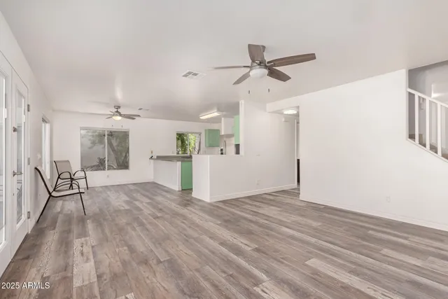 a view of empty room with wooden floor and window