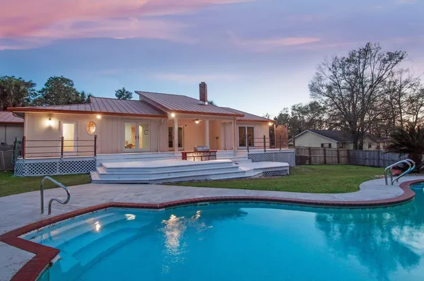 a front view of a house with swimming pool having outdoor seating