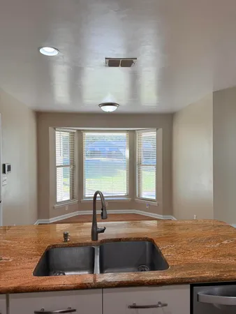 a bathroom with a granite countertop sink and window