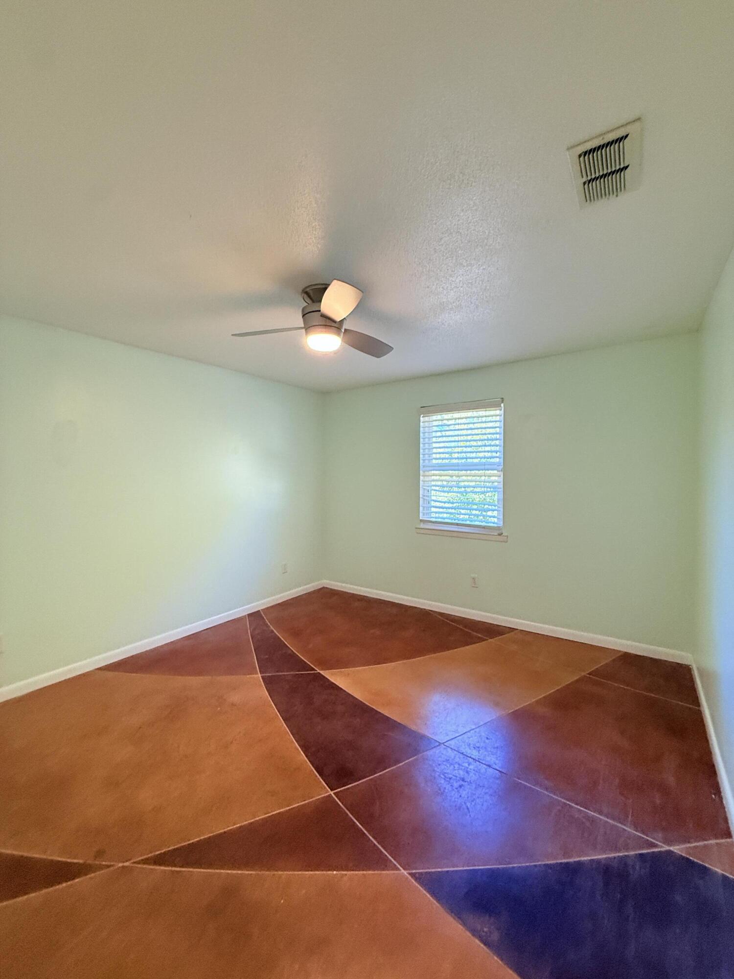255 Ridge Lake Road Crestview, FL 32536 - Photo 18 of 39 a view of an empty room with wooden floor and fan