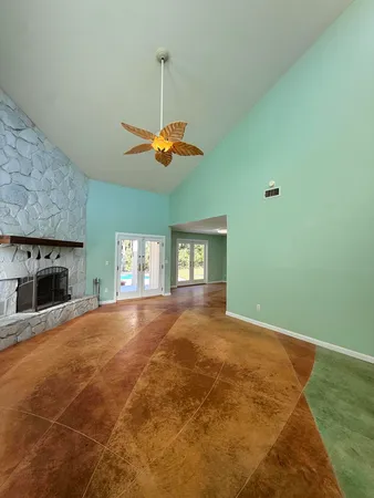 a view of an empty room with window and fireplace