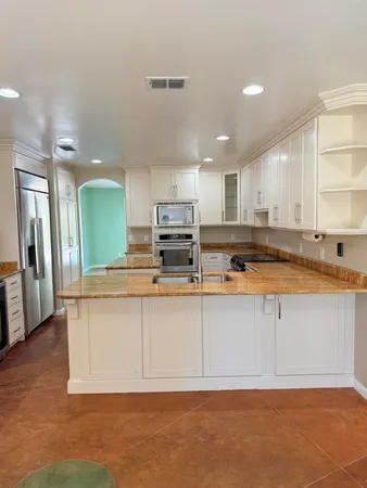 a kitchen with stainless steel appliances granite countertop a stove a sink and a microwave