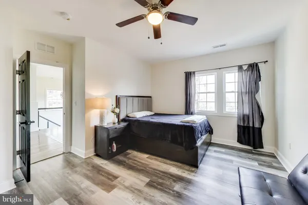a view of an empty room with window and a ceiling fan