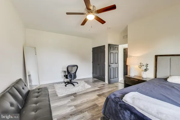 a view of empty room with wooden floor and fan