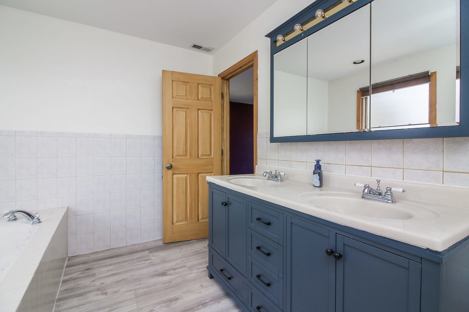 1128 South Wolf Road Des Plaines, IL 60016 - Photo 12 of 20 a bathroom with a sink and a mirror