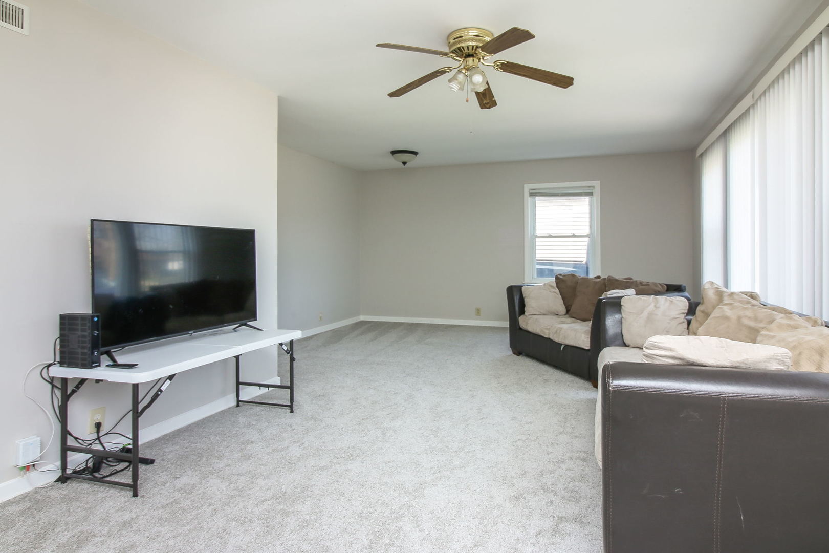1128 South Wolf Road Des Plaines, IL 60016 - Photo 2 of 20 a living room with furniture and a flat screen tv