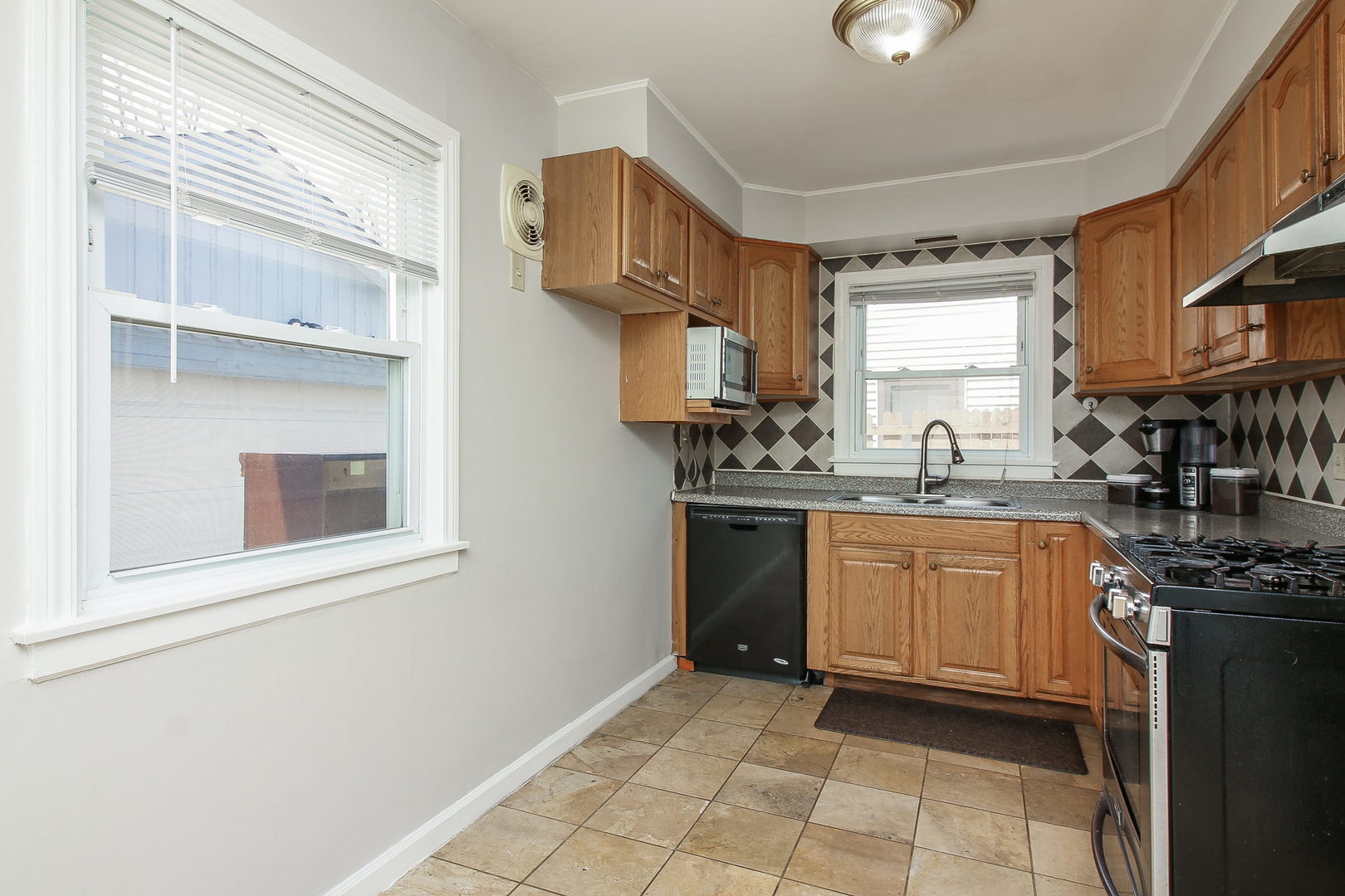 1128 South Wolf Road Des Plaines, IL 60016 - Photo 6 of 20 a kitchen with stainless steel appliances granite countertop a stove a sink and a refrigerator