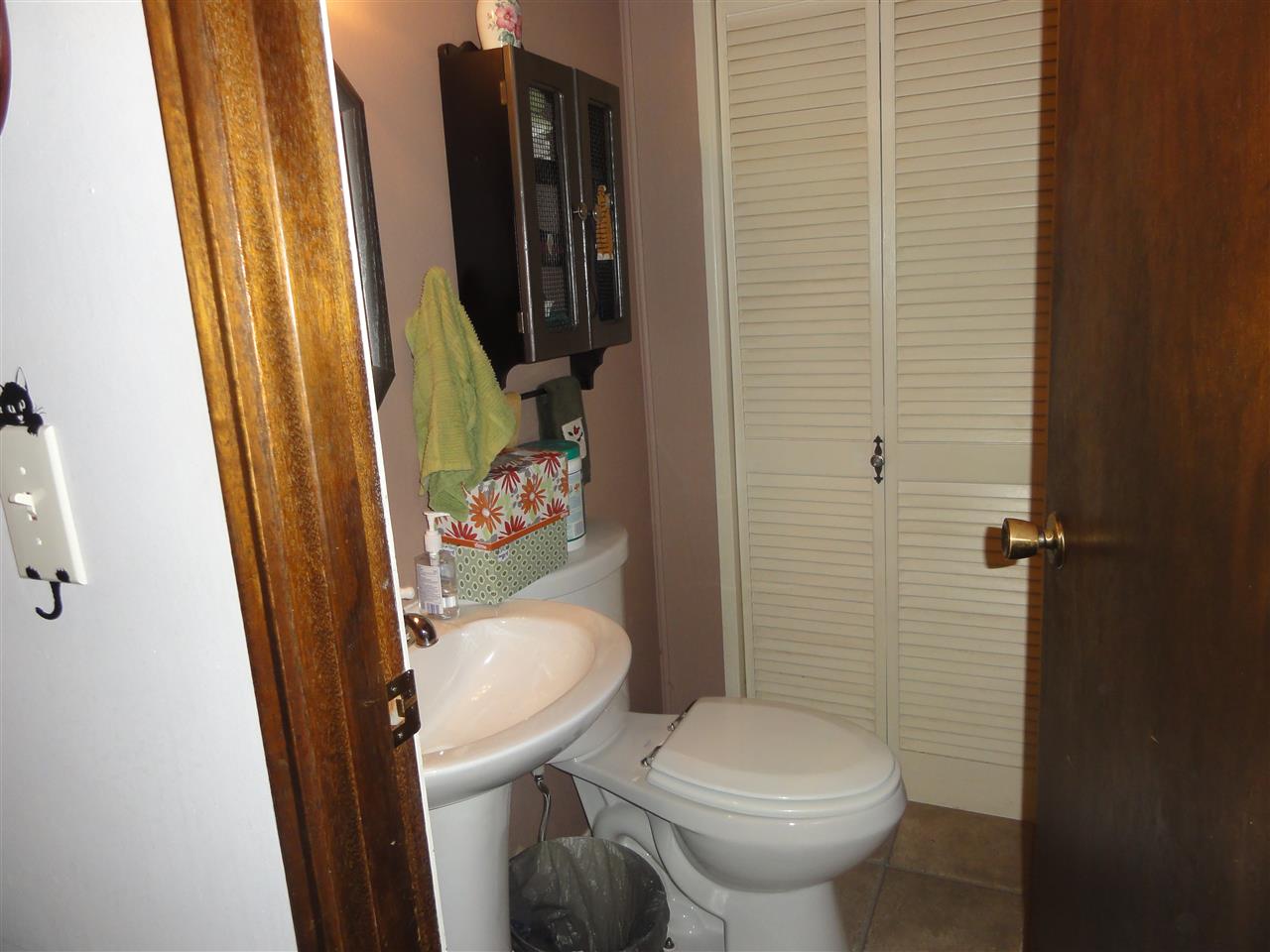 14913 Prairie Road Rockton, IL 61072 - Photo 14 of 19 a white toilet sitting next to a bathroom sink and a mirror