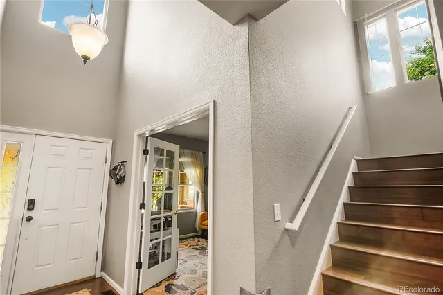 a view of a hallway with wooden floor and staircase