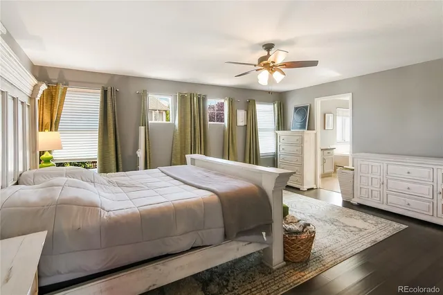 a bedroom with a large bed and wooden floor