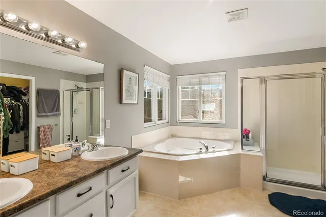 a bathroom with a granite countertop tub sink and mirror