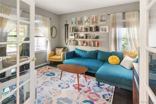 a living room with furniture and a floor to ceiling window or book shelf