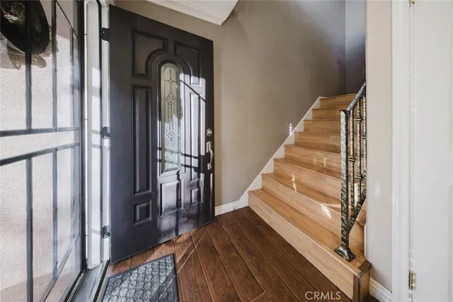 a view of a hallway with wooden floor and staircase