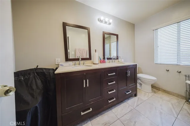 a bathroom with a double vanity sink toilet mirror and bathtub