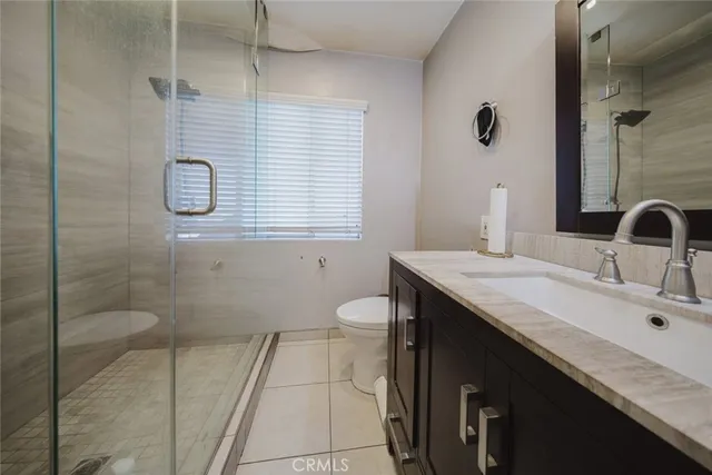 a bathroom with a granite countertop sink a toilet and shower