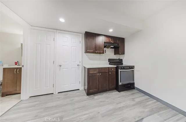 a kitchen with a refrigerator and a stove top oven