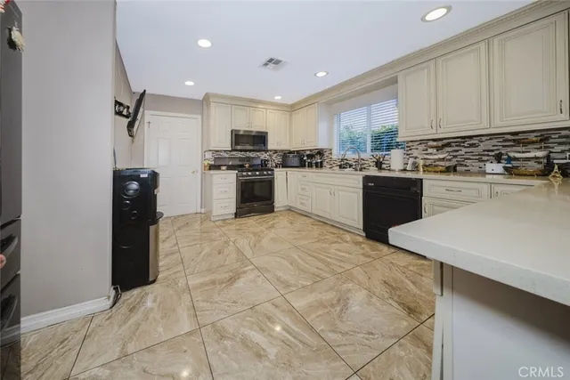 a kitchen with stainless steel appliances kitchen island granite countertop a refrigerator sink and stove