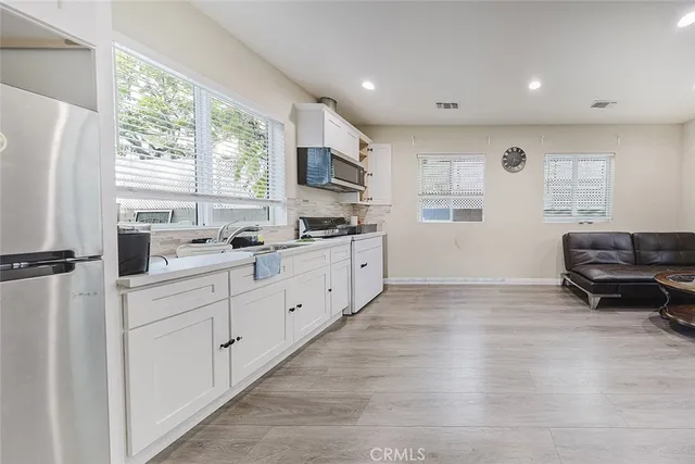 a kitchen with stainless steel appliances granite countertop a refrigerator and a stove top oven
